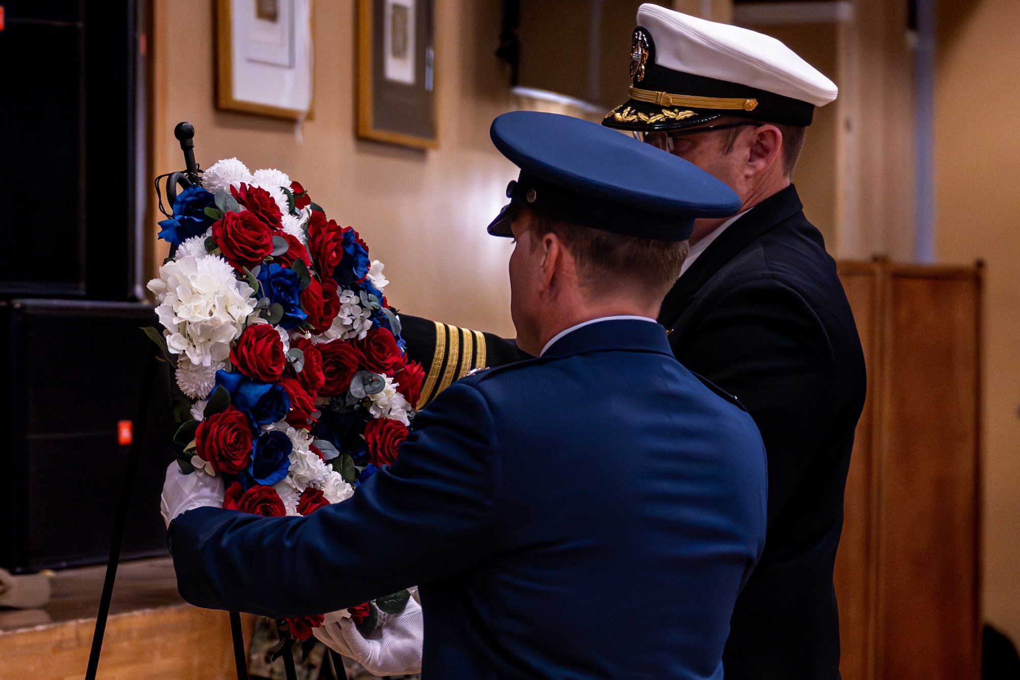 An Air Force Col. and Navy Capt. hang a wreath.
