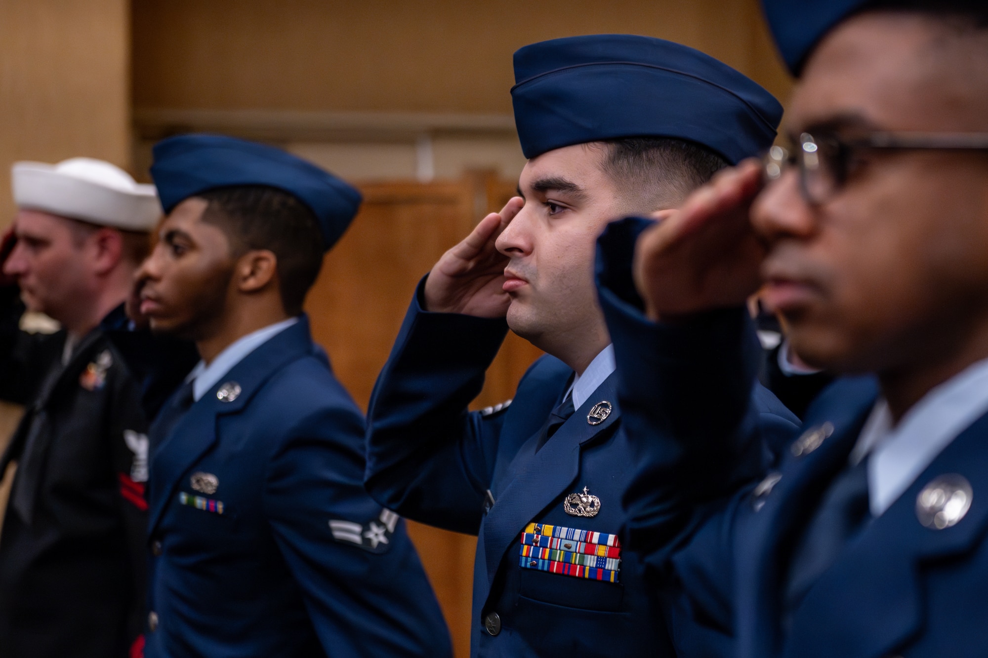 Uniformed members salute during the playing of "Taps."
