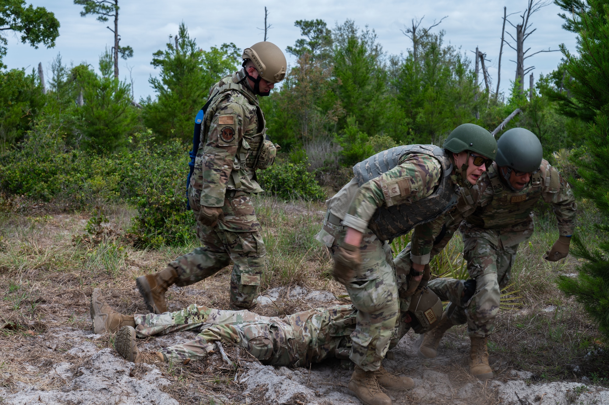 U.S. Air Force Airmen assigned to the 21st Air Task Force transport a simulated casualty during exercise CHAOS RISING at a Combat Support Training Range location, Tyndall Air Force Base, Florida, May 9, 2025. This rigorous training ensured 21st ATF Airmen are mission ready by honing capabilities that enable operating from smaller, dispersed locations to generate and sustain combat airpower. (U.S. Air Force photo by Senior Airman Alondra Cristobal Hernandez)