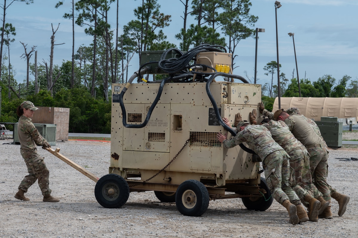 U.S. Air Force Airmen assigned to the 21st Air Task Force move a generator into place during exercise CHAOS RISING at Tyndall Air Force Base, Florida, May 10, 2025. The training exercise occurred at a Combat Support Training Range and allowed the 21st ATF to exercise command and control elements using an Agile Combat Employment design rather than a traditional beddown, enhancing their flexibility and mobility. (U.S. Air Force photo by Senior Airman Alondra Cristobal Hernandez)