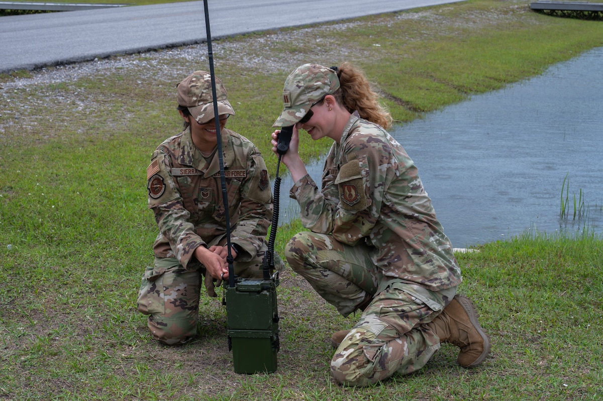U.S. Air Force Staff Sgt. Breauna, 7th Logistics Readiness Squadron NCO in charge of material management, and Capt. Erin Stutts, 96th Operational Medical Readiness Support Squadron physical therapist, practice radio training during exercise CHAOS RISING at Tyndall Air Force Base, Florida, May 10, 2025. Training in a Combat Support Training Range allows Airmen to hone expeditionary skills and develop capabilities outside of their core Air Force Specialty Codes in austere conditions. (U.S. Air Force photo by Senior Airman Alondra Cristobal Hernandez)