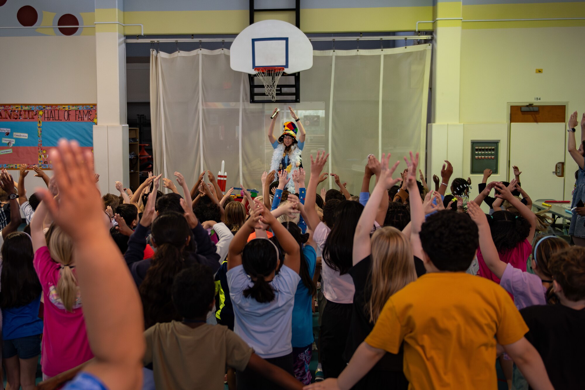 Students raise their hands in unison during a demonstration about the U.S. Space Force.