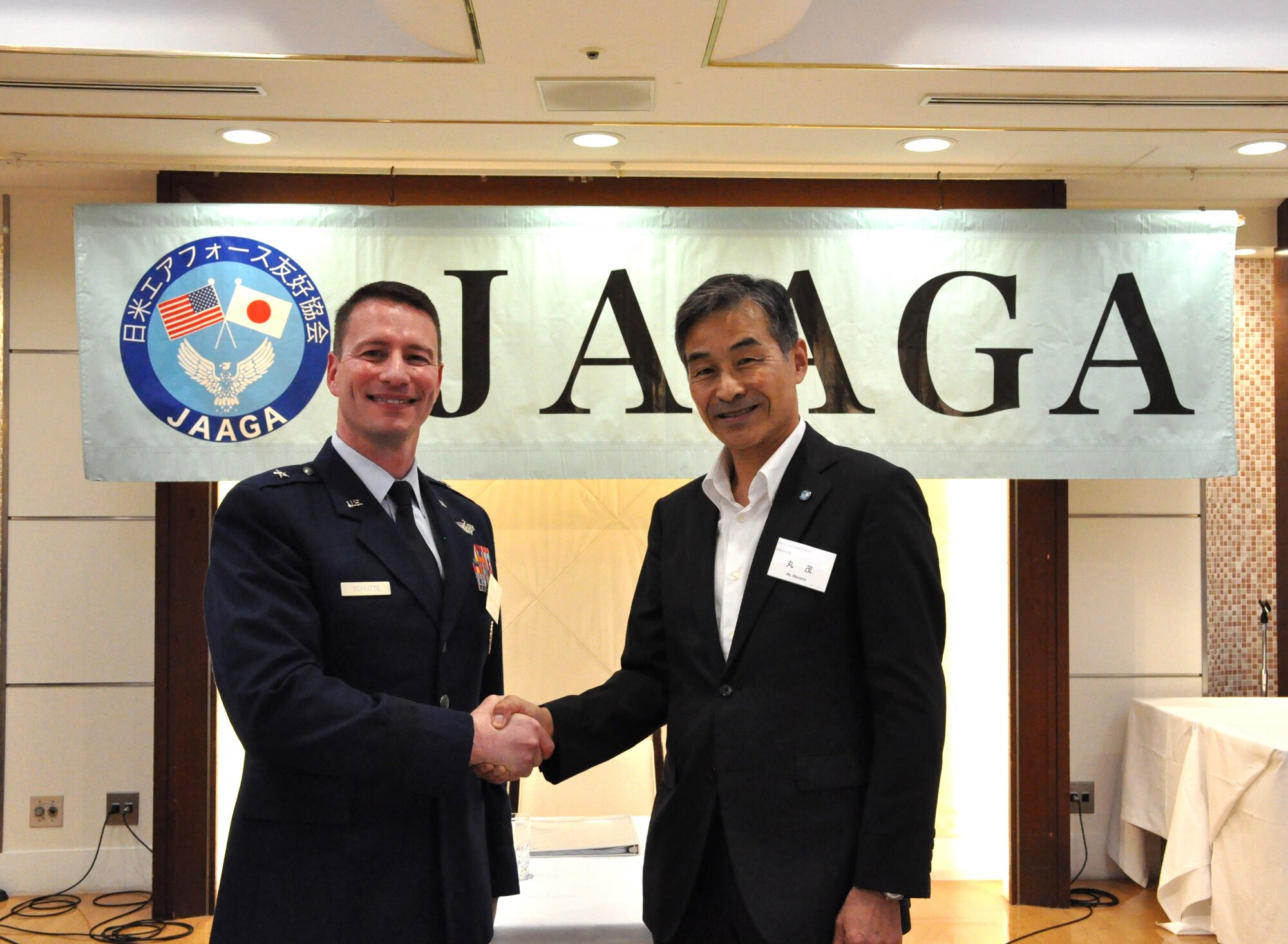 U.S. Air Force Brigadier General John Schutte, Fifth Air Force Deputy Commander, and Mr. Yoshinari Marumo, Japan America Goodwill Association President, shake hands at the JAAGA Annual Convention at Grand Hill Ichigaya, Japan, May 13, 2025. The JAAGA convention provides an opportunity for senior military leaders to reflect on the successes their organizations have accomplished separately and collaboratively over the year.  (U.S. Air Force photo by Captain Tisha Yates)