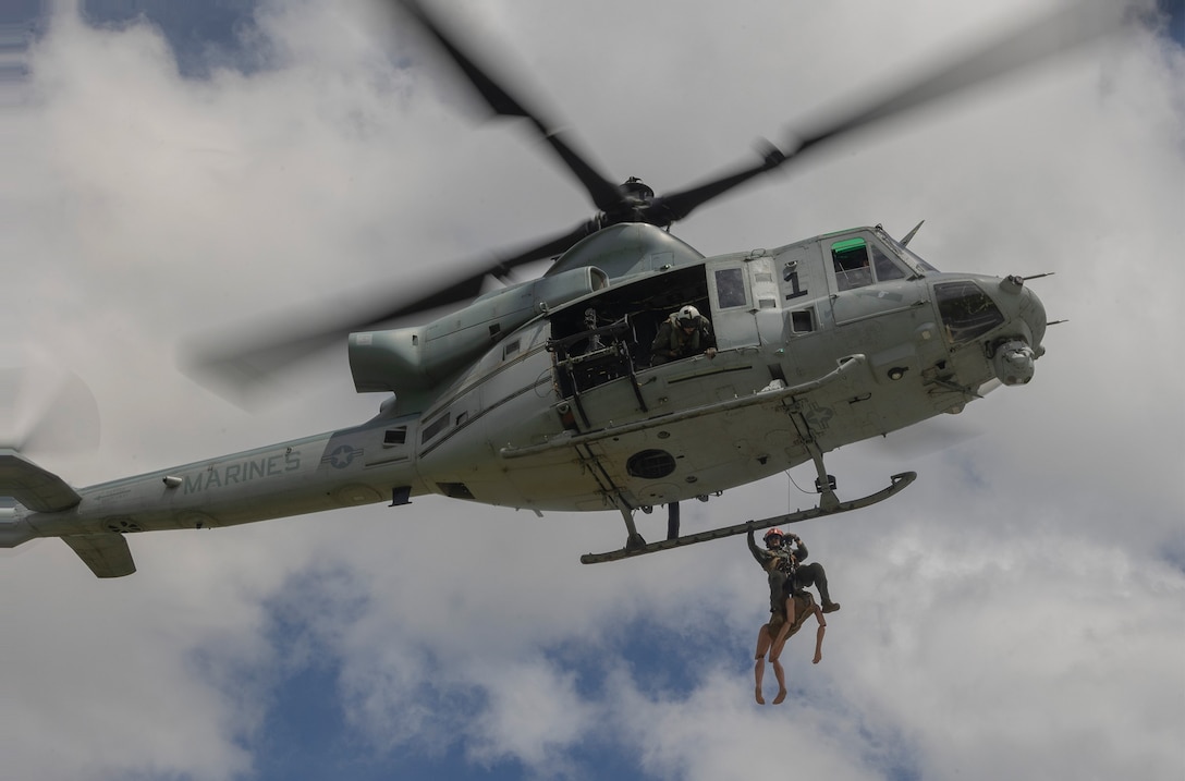 U.S. Navy Sailor Petty Officer 2nd Class Kristin Cove, a field medical technician with 3rd Medical Battalion, 3rd Marine Logistics Group, hoists a simulated casualty onto a UH-1Y Venom helicopter assigned to Marine Medium Tiltrotor Squadron (VMM) 265 (Rein.), 31st Marine Expeditionary Unit, during a casualty evacuation exercise on Marine Corps Air Station Futenma, Okinawa, Japan, May 21, 2025. Marines and Sailors conducted ground and air hoist guidance and tactical combat casualty care techniques in rural terrain scenarios. The 31st MEU, the Marine Corps’ only continuously forward deployed MEU, provides a flexible and lethal force, ready to perform a wide range of military operations as the premiere crisis response force in the Indo-Pacific region. (U.S. Marine Corps photo by Lance Cpl. Skilah Sanchez)