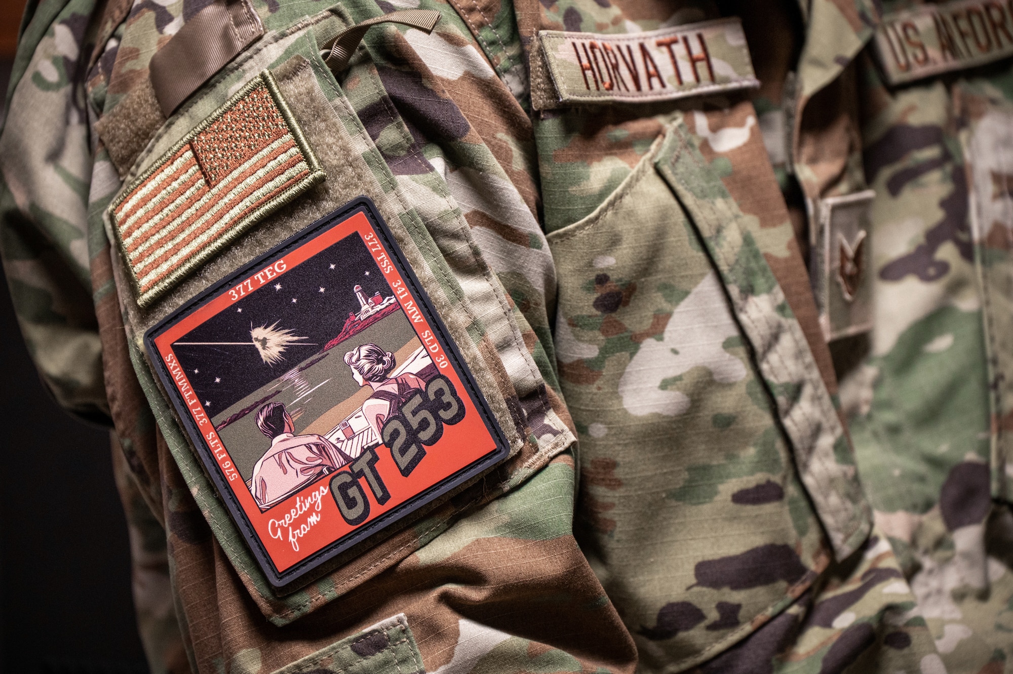 A close-up photo of someone in green camouflage uniform with vintage-designed morale patch on their shoulder.