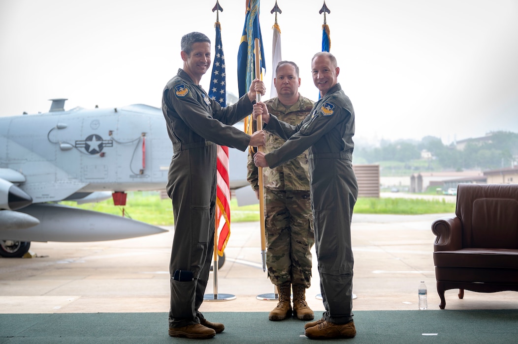 U.S. Air Force Col. Kurt Distelzweig, incoming 51st Operations Group commander, receives the unit guidon from Col. William McKibban, 51st Fighter Wing commander, during a change of command ceremony at Osan Air Base, Republic of Korea, May 22, 2025.