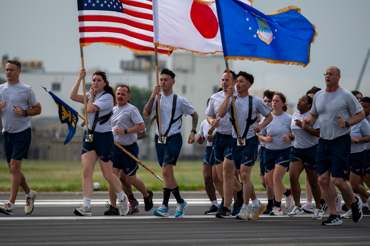 Military members run on the flightline.