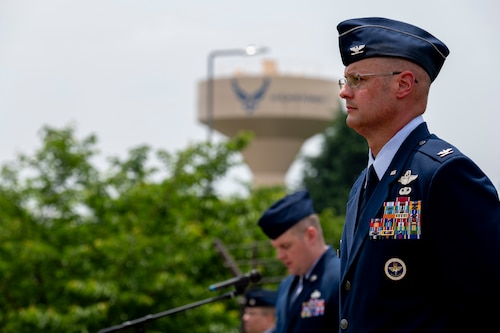 A military member stands at parade rest.