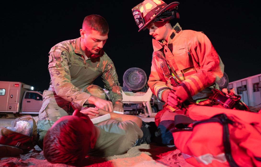 A medic and firefighter attend to a simulated casualty.