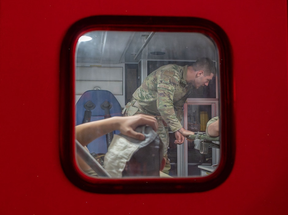 A man is shown through a window on the back door of an ambulance.
