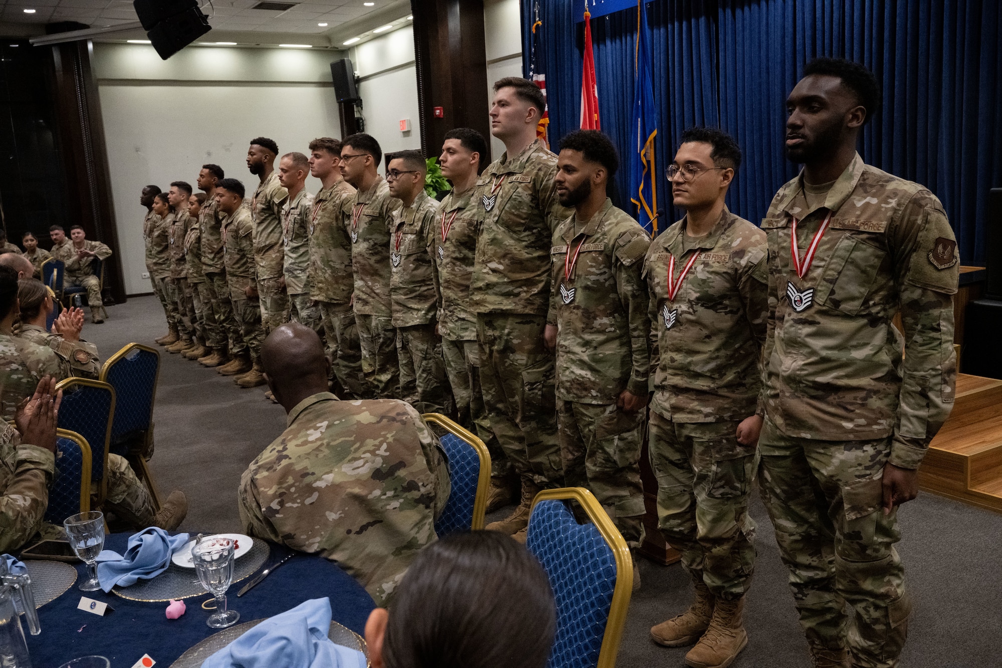 Airman Leadership School grduates stand at attention during an Airman Leadership School graduation ceremony at Incirlik Air Base, Türkiye, May 22, 2025. ALS is designed to prepare senior airmen for positions of greater responsibility by strengthening their ability to lead, follow, and manage while also gaining a broader understanding of the military profession and their role within the Air and Space Forces.