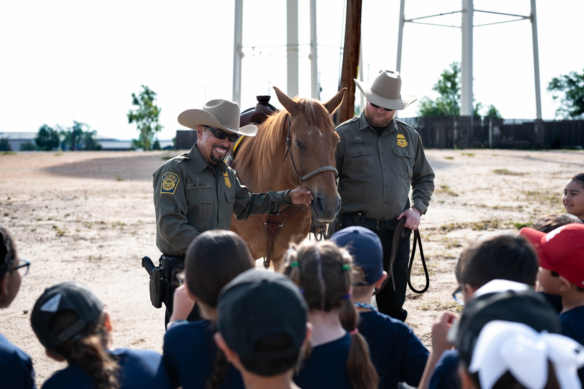 U.S. Border Patrol agents from the Del Rio Sector introduce local students to a mounted patrol horse during a National Police Week Expo at Laughlin Air Force Base, Texas, May 15, 2025. The event highlighted partnerships between law enforcement agencies and offered hands-on demonstrations for visiting youth. (U.S. Air Force photo by Senior Airman Keira Rossman)