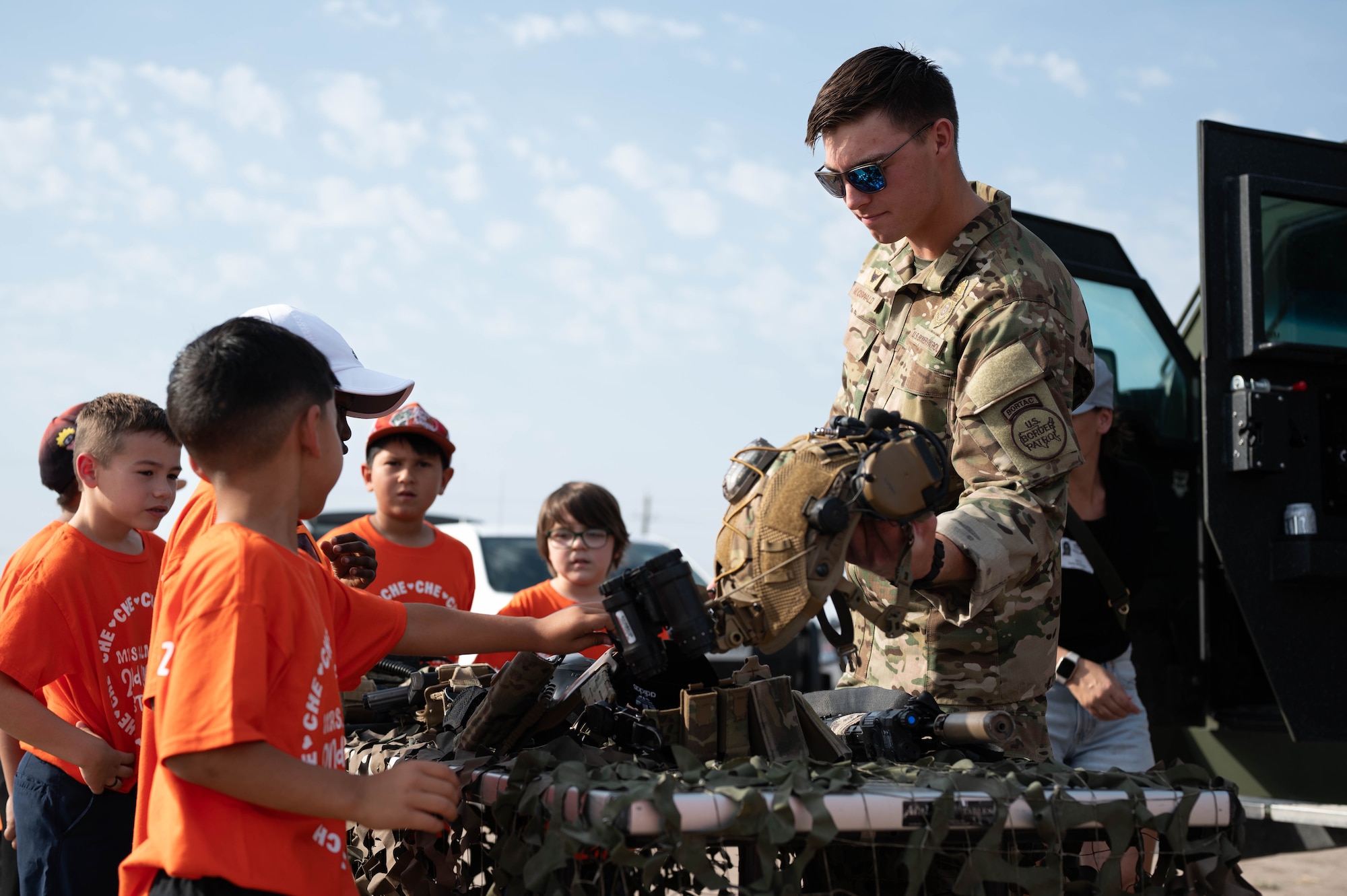 A U.S. Border Patrol Tactical Unit member explains specialized equipment to students during a National Police Week Law Enforcement Expo at Laughlin Air Force Base, Texas, May 15, 2025. Law enforcement agencies across the region partnered to showcase their capabilities and engage with the local community. (U.S. Air Force photo by Senior Airman Keira Rossman)