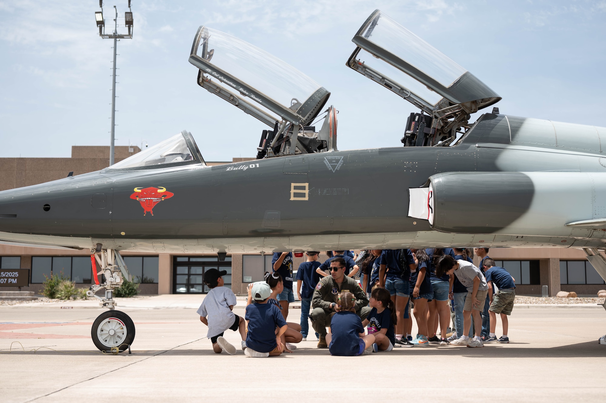 U.S. Air Force 2nd Lt. Alex Ehrenstein, 47th Student Squadron, speaks to students under a T-38C Talon during a Ceniza Hills School tour at Laughlin Air Force Base, Texas, May 15, 2025. The event showcased Laughlin’s mission and inspired young visitors. (U.S. Air Force photo by Senior Airman Keira Rossman)
