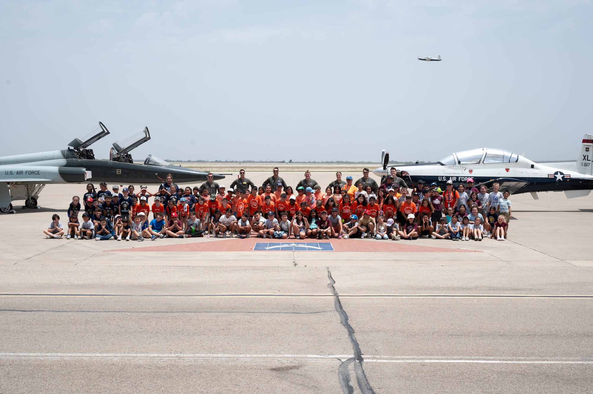 Students, teachers and Airmen pose for a group photo between a T-38C Talon and a T-6A Texan II during a Ceniza Hills School tour at Laughlin Air Force Base, Texas, May 15, 2025. The field trip gave youth a first-hand look at the aircraft and people behind Air Force pilot training. (U.S. Air Force photo by Senior Airman Keira Rossman)
