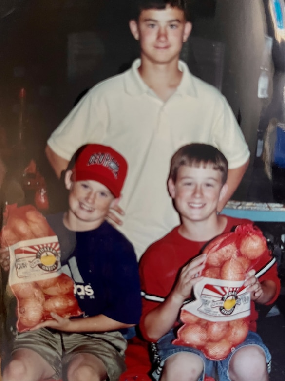 Staff Sgt. Dustin Wright (left), shown in a childhood photo alongside his older brothers Ardie Wright (center), and Staff Sgt. Will Wright (left), at their grandfather’s onion farm warehouse, in Lyons, Georgia.