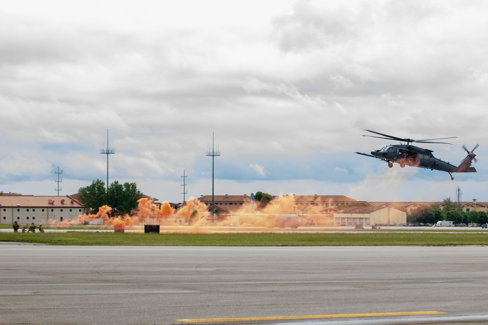Helicopter aerial demo displaying orange smoke.