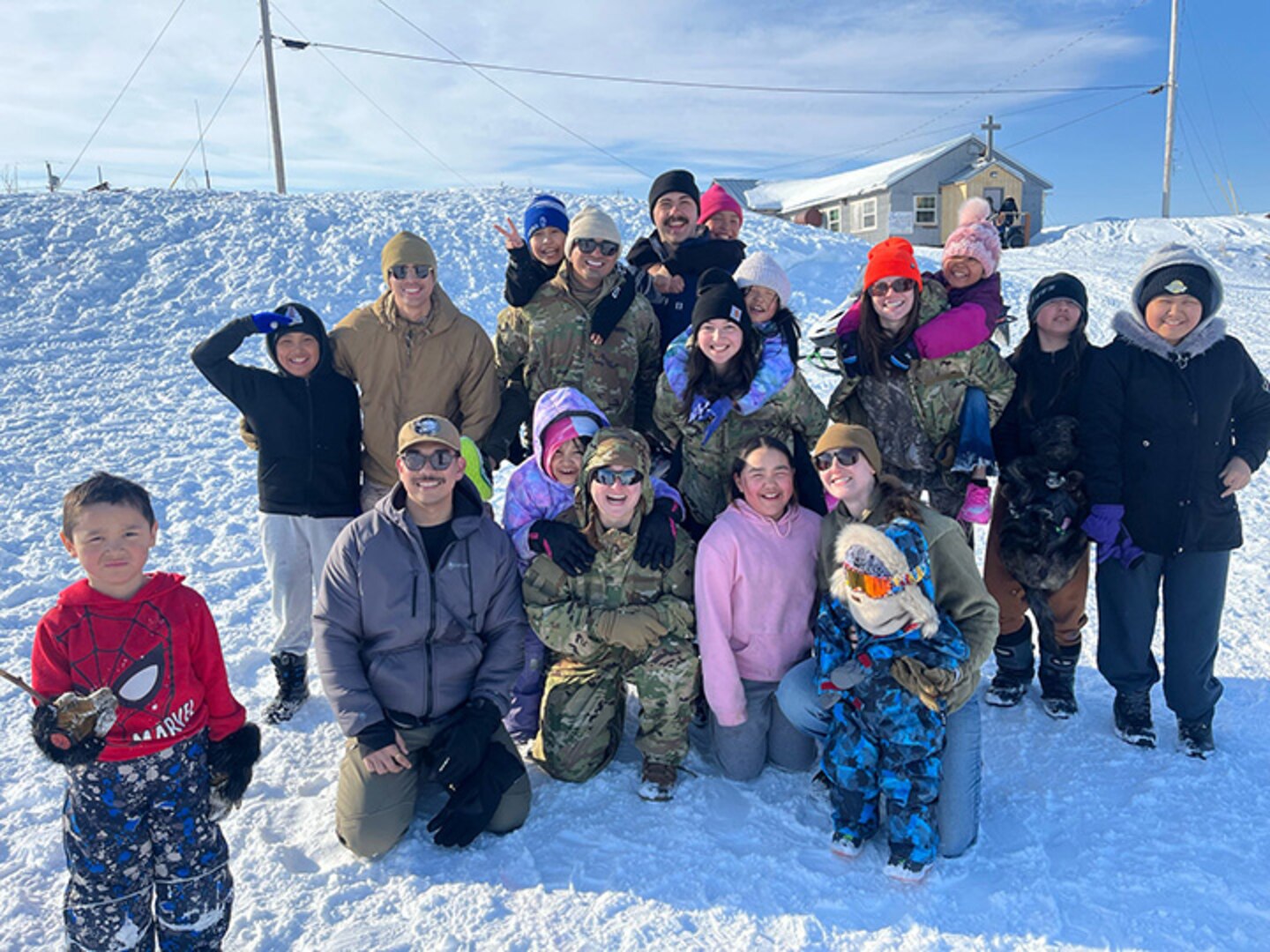 The New Hampshire Army National Guard Medical Readiness Detachment, as part of a joint medical team assigned to the village of Selawik, pose for a photo with local students following a snowball fight during Operation Arctic Care, April 13, 2025, in Selawik, Alaska.