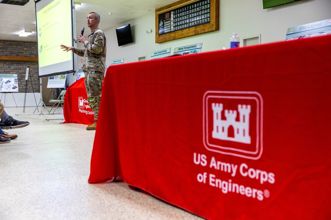 A man speaks to a crowd in an event hall.