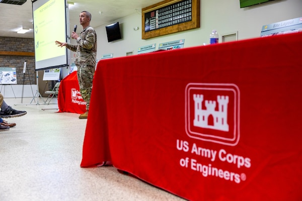 A man speaks to a crowd in an event hall.