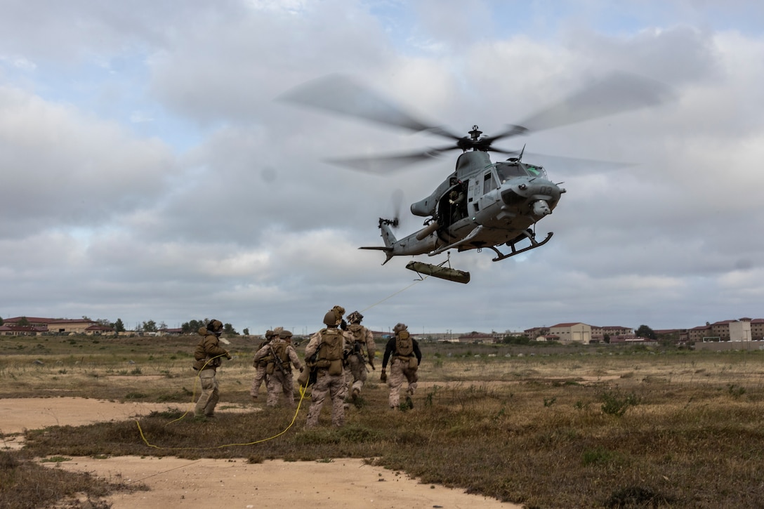 U.S. Marines with 3rd Battalion, 1st Marines, 1st Marine Division, steady a SKED device being airlifted onto a UH-1Y Venom attached to Marine Light Attack Helicopter Squadron (HMLA) 369 during a tactical recovery of aircraft and personnel course hosted by Amphibious Raids Branch, Expeditionary Operations Training Group, I Marine Expeditionary Force, at Marine Corps Base Camp Pendleton, California, May 12, 2025.