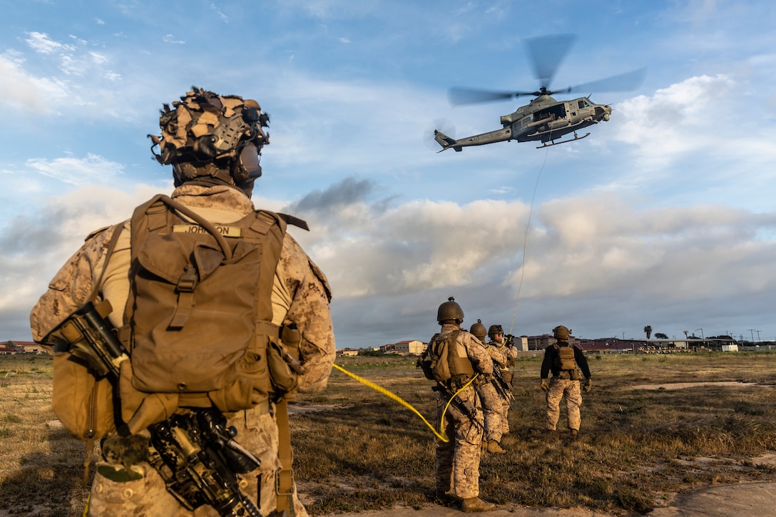 U.S. Marines with 3rd Battalion, 1st Marines, 1st Marine Division, steady a SKED device as it is airlifted onto a UH-1Y Venom attached to Marine Light Attack Helicopter Squadron (HMLA) 369 during a tactical recovery of aircraft and personnel course hosted by the Amphibious Raids Branch, Expeditionary Operations Training Group, I Marine Expeditionary Force, at Marine Corps Base Camp Pendleton, California, May 12, 2025.