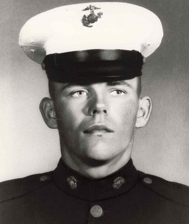 A man wearing a military uniform and cap poses for a photo.