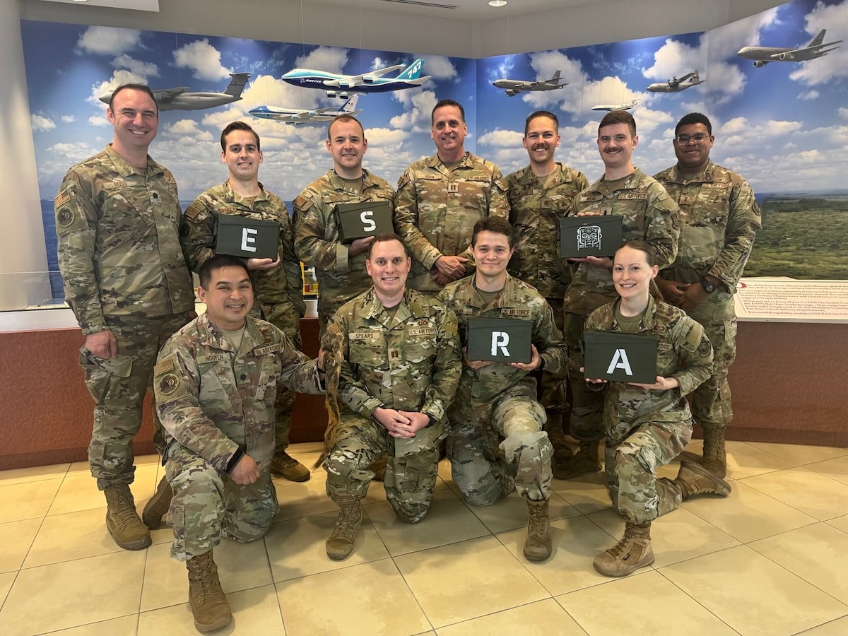 The Air Mobility Command Rapid Innovation Team poses for a photo with ESRA, one of their early projects and a precursor to Revolutionary AI Production, Innovation and Deployment. ESRA was the first artificial intelligence at the secret level and won the team their first Air Force level award. (Courtesy photo)