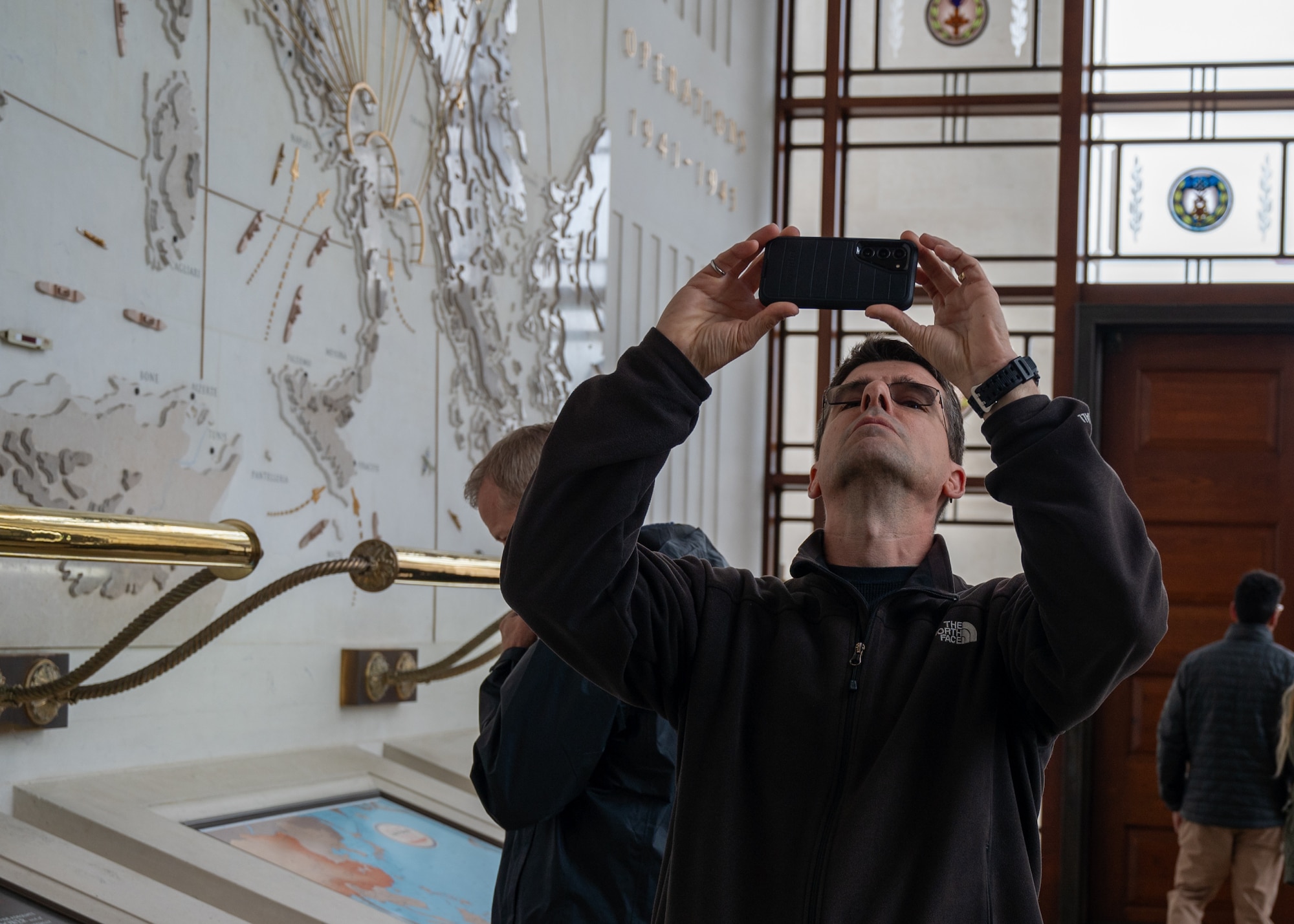 Male photographs a ceiling inside a chapel