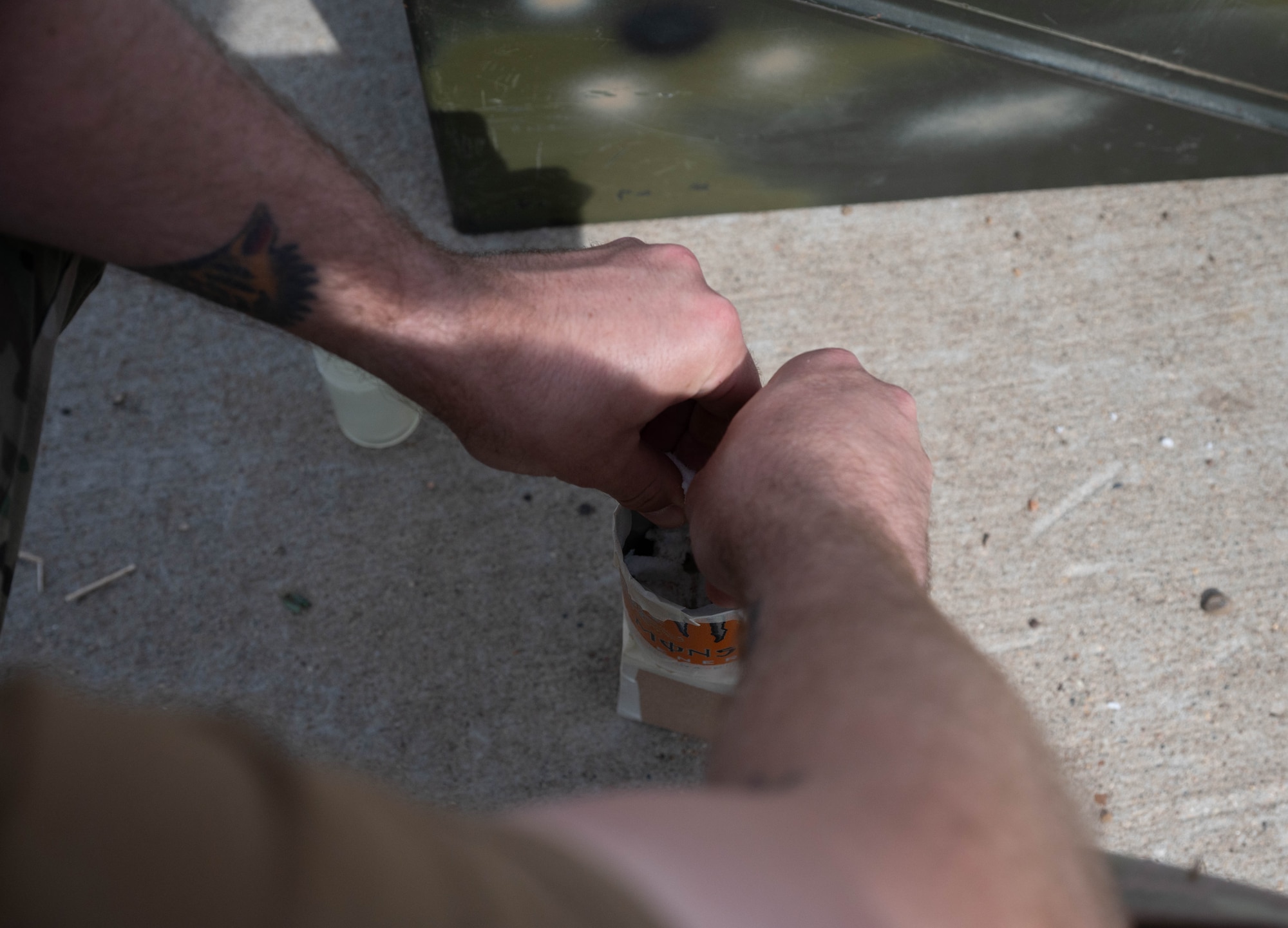 Tech. Sgt. Taylor Tompkins, 5th Civil Engineer Squadron Explosive Ordnance Disposal team leader, packs M112 demolition block C4 into an improvised shape charge at Minot Air Force Base, North Dakota, May 12, 2025. An improvised shape charge is used during training to help Airmen distinguish what impact the material used can have on an explosive. (U.S. Air Force photo by Airman 1st Class Wesley Davies)