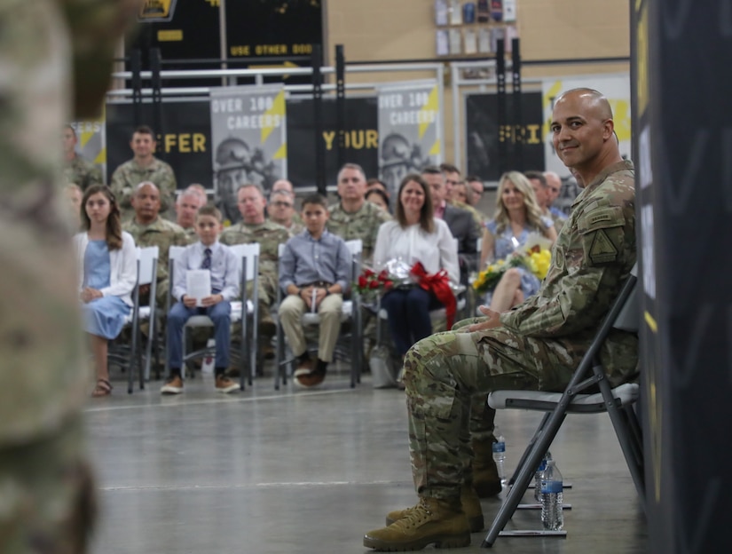 Outgoing commander, U.S. Army Lt. Col. Jason Mendez looks on with his family in the background as Brig. Gen. Joseph Lear, director of the joint staff, speaks about Mendez’s accomplishments while he was in command during the Recruiting and Retention Battalion’s change of command ceremony at Wellman Armory on Boone National Guard Center in Frankfort May 20, 2025.