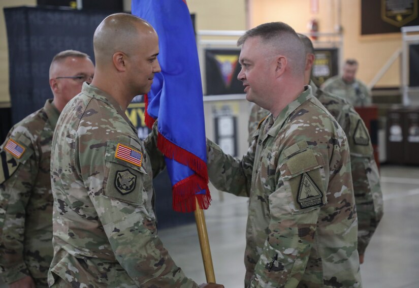 U.S. Army Command Sgt. Maj. Bryan Reed hands off the unit guidon to outgoing commander Lt. Col. Jason Mendez, signifying the exchange of command during the Recruiting and Retention Battalion’s change of command ceremony at Wellman Armory on Boone National Guard Center in Frankfort May 20, 2025.