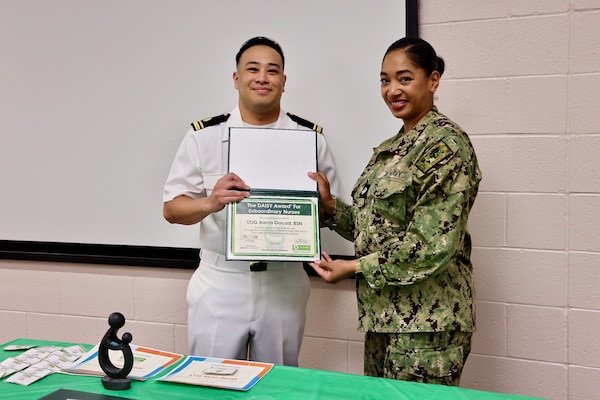 Lt. j.g. Aaron Gracad (left), a San Diego, Calif. native working in the Maternal Infant Nursing Department is honored during the 2025 DAISY Award ceremony held at Naval Hospital Twentynine Palms on May 16. The DAISY Award recognizes outstanding nursing professionals who demonstrate exceptional compassion and dedication to patient-centered care. The event also highlighted nominees from multiple hospital departments, showcasing the wide-reaching commitment to quality healthcare across the facility (U.S. Navy photo by Christopher C. Jones, NHTP/NMRTC Twentynine Palms public affairs officer).