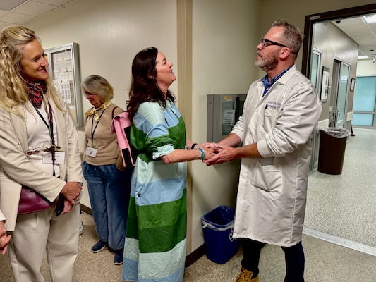 250516-N-WJ173-1002  SAN DIEGO (May 16, 2025) – Katie Murray, spouse of Royal Australian Navy Rear Adm. Ian Murray, presents a coin to Derek Dudek, Naval Medical Center San Diego (NMCSD) Training Specialist for Medical Simulation, in appreciation for his engaging and informative briefing during a tour of the BioSkills department, May 16, 2025. The gesture took place during the Spring 2025 Foreign Defense Attaché Orientation Program and reflected the group's gratitude for NMCSD’s professionalism and innovation. The mission of NMCSD is to provide a superior experience for our patients, staff, and warfighters. NMCSD employs more than 5,000 active-duty military personnel, civilians, and contractors in Southern California to deliver exceptional care afloat and ashore.