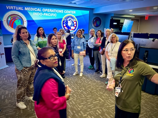 250516-N-WJ173-1003 DIEGO (May 16, 2025) – Lynn Campbell (R), a registered nurse assigned to the Joint Tele-Critical Care Network (JTCCN) at Naval Medical Center San Diego (NMCSD), briefs Foreign Defense Attaché spouses on the capabilities of the Virtual Medical Operations Center (VMOC) during their visit as part of the Spring 2025 Foreign Defense Attaché Orientation Program, hosted by the Defense Intelligence Agency, May 16, 2025. The tour highlighted the Navy’s use of telemedicine and real-time coordination platforms to enhance medical readiness and support warfighters worldwide. The mission of NMCSD is to provide a superior experience for our patients, staff, and warfighters. NMCSD employs more than 5,000 active-duty military personnel, civilians, and contractors in Southern California to deliver exceptional care afloat and ashore.