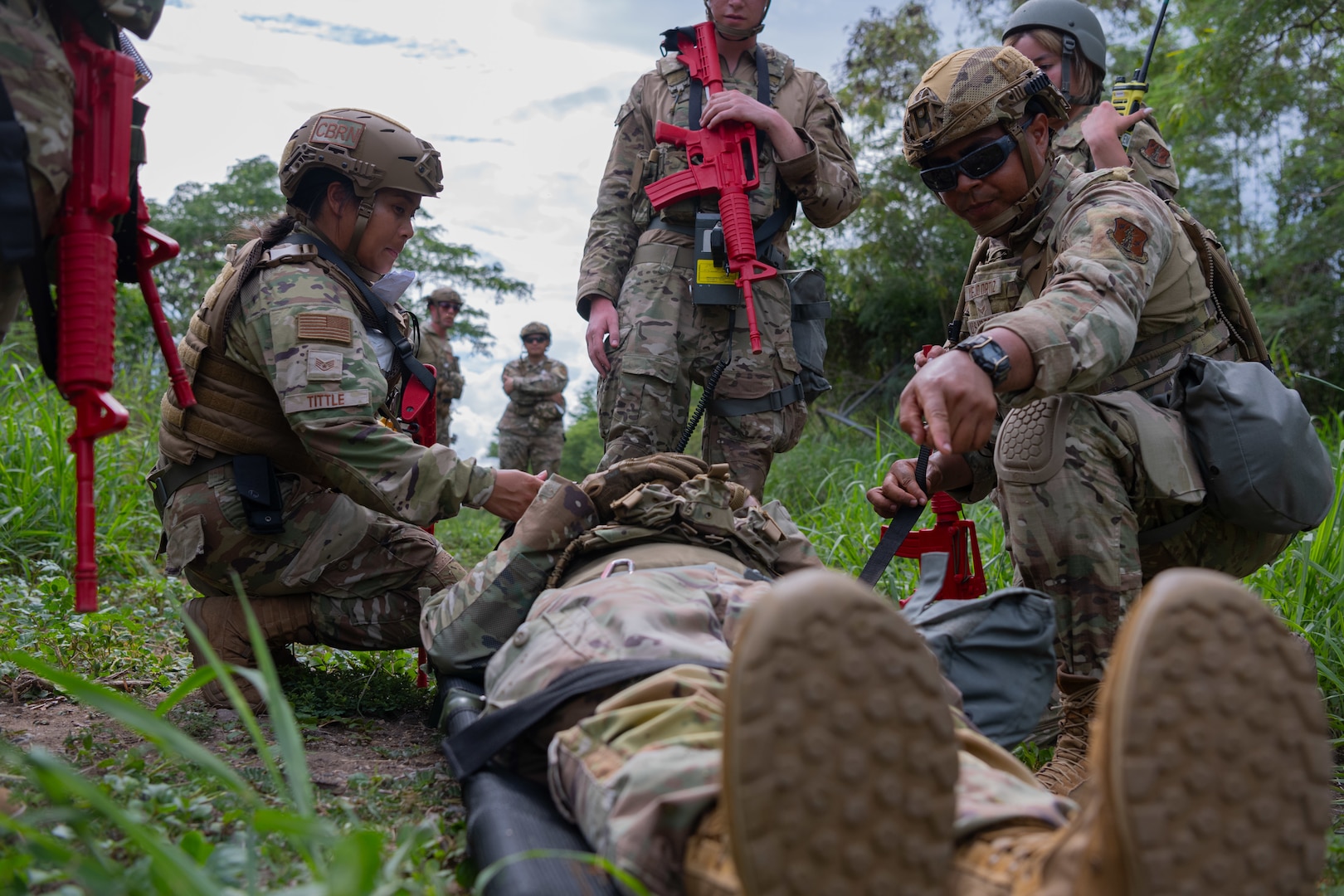 U.S. Air Force Staff. Sgt. Chastilynn Tittle, an emergency management specialist with the 154 Civil Engineer Squadron, Hawaii Air National Guard, left, and Staff Sgt. Ashviel Cruz Aponte, an emergency management specialist with the 156th Civil Engineer Squadron, Puerto RicoAir National Guard, strap an airman on a stretcher during the 2025 Virgin Islands and Puerto Rico emergency management Deployment for Training at Fort Allen, Juana Diaz, Puerto Rico, May 18, 2025. The 2025 VIPR EM DFT measured multiple ANG civil engineer squadrons’ mission readiness by simulating an austere location to prepare participating Airmen to execute the Agile Combat Employment Concept within the U.S. Air Force Indo-Pacific Command area of responsibility. (U.S. Air National Guard photo by 1st Lt. Eliezer Soto)
