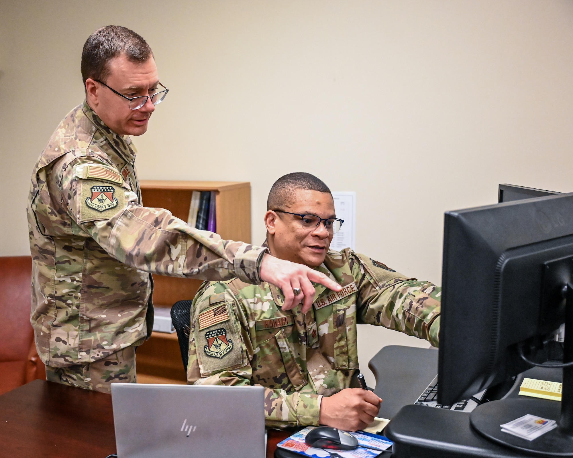 U.S. Air Force Lt. Col. Kevin Normile, left, 445th Airlift Wing Staff Judge Advocate, and Maj. Karrie Howard, 445 AW Deputy JA, review legal documents at Wright- Patterson Air Force Base, Ohio, April 6, 2025. (U.S. Air Force photo by Staff Sgt. Jonathan Quiñones)