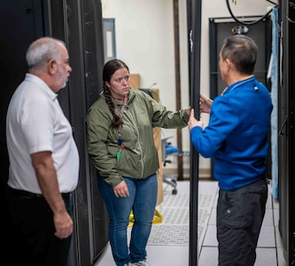 Penguin Computing personnel on site during HPC server installation May 9, 2025. As part of a first-of-its-kind lease agreement, Kelsey N. Beall (center), an engineer from Penguin, will work full-time alongside Carderock SeaTech engineers to provide routine updates, troubleshooting, and system support.