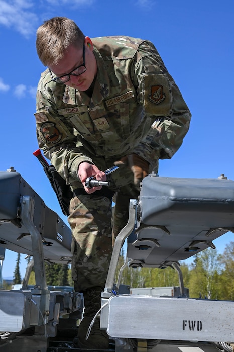 U.S. Air Force Staff Sgt. Jacob Comer, 354th Munitions Squadron stockpile management crew chief, prepares ordnance for transport during the Combat Ammunition Production Exercise (CAPEX) at Eielson Air Force Base, Alaska, May 14, 2025.