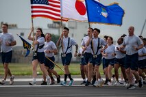 Military members run on the flightline.