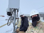Master Sgt. Philip Nelson and Master Sgt. Jonathan Wilson of the 168th Communications Flight pose for a photo while installing broadband satellite, and 5 G Cellular Service in Shishmaref, Alaska. The installation, completed over five demanding days, was part of a larger initiative funded by a $29.5 million grant awarded to Alaska Tribal Networks, a nonprofit focused on expanding broadband access to rural villages. The recent Shishmaref deployment marked the beginning of a broader plan that includes coordinating the provision of Broadband satellite and 5G fixed and mobile wireless services in 45 communities across the Arctic. Nelson and Wilson of the 168 CF and ATS Lead Technician Brian Vaughn collaborated closely with the Department of Defense's Innovative Readiness Training program to execute the installation in Shishmaref. They extended the existing Starlink service from a community building into a 4G/5G broadcast signal, blanketing the entire village with reliable connectivity. (U.S. Air National Guard photo by Senior Master Sgt. Julie Avey)