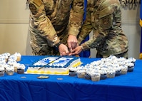 Airmen slice into a cake in honor of AFSOC’s 35th birthday.