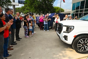 Tech. Sgt. Martha Rodriguez, a 433rd Security Forces Squadron fire team leader, embraces her family after seeing their new vehicle donated through USAA and the National Auto Body Council Recycled Rides program April 30, 2025 in San Antonio, Texas.