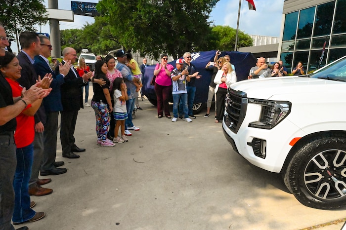 Tech. Sgt. Martha Rodriguez, a 433rd Security Forces Squadron fire team leader, embraces her family after seeing their new vehicle donated through USAA and the National Auto Body Council Recycled Rides program April 30, 2025 in San Antonio, Texas.