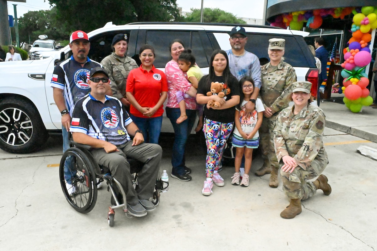 Tech. Sgt. Martha Rodriguez, a 433rd Security Forces Squadron fire team leader, poses for a photo with her leadership and representatives of the non-profit that nominated her to receive a new vehicle donated through USAA and the National Auto Body Council Recycled Rides program April 30, 2025 in San Antonio, Texas.