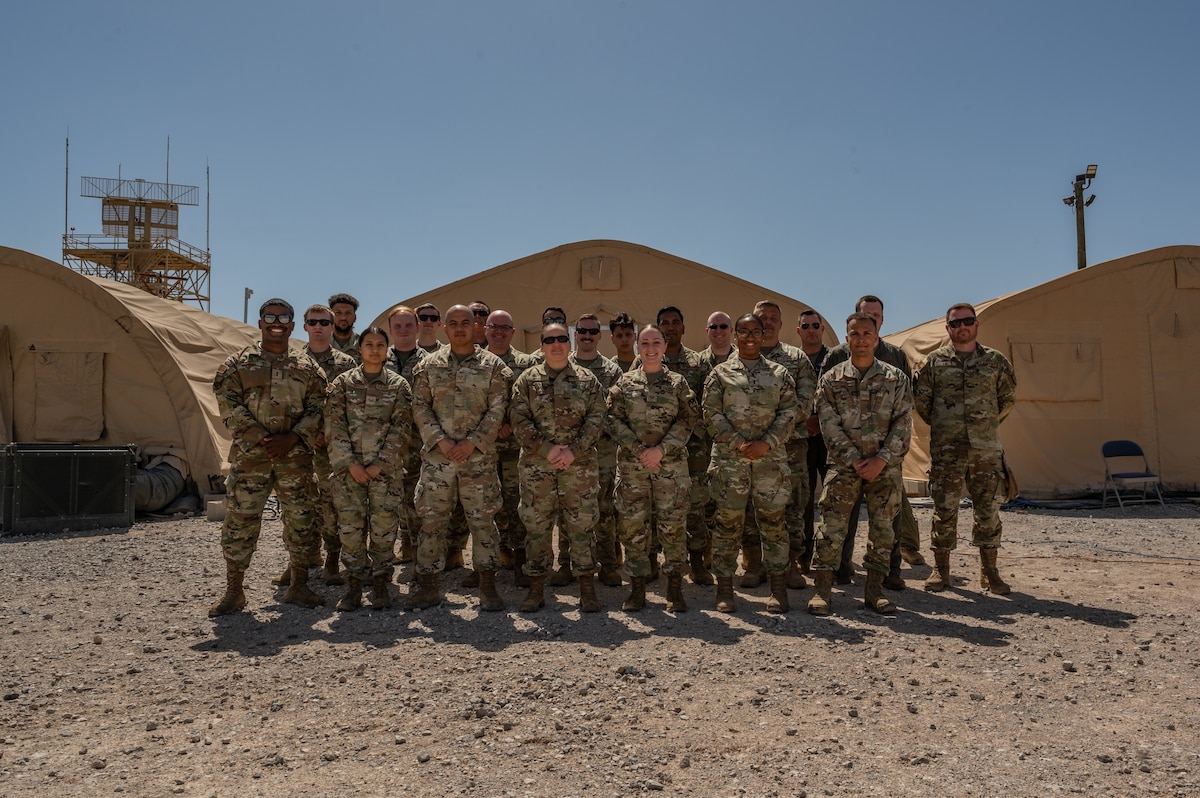 U.S. Airmen assigned to the 612th Air Operations Center (AOC) and 612th Air Communications Squadron stand for a photo during a mock deployment at Nellis Air Force Base, Nevada, May 13, 2025. As part of the exercise, the AOC-deployable team conducted a comprehensive test to assess the operational concept for a deployed C2 capability, ensuring mission readiness anytime, anywhere.  (U.S. Air Force photo by Airman 1st Class Jennifer Nesbitt)