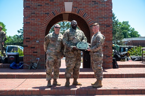 John Poole, 375th Air Mobility Wing commander, awards a championship belt to Senior Airman David Bailey from the 375th Force Support Squadron, following the pugil stick tournament during the Warrior Challenge at Scott Air Force Base