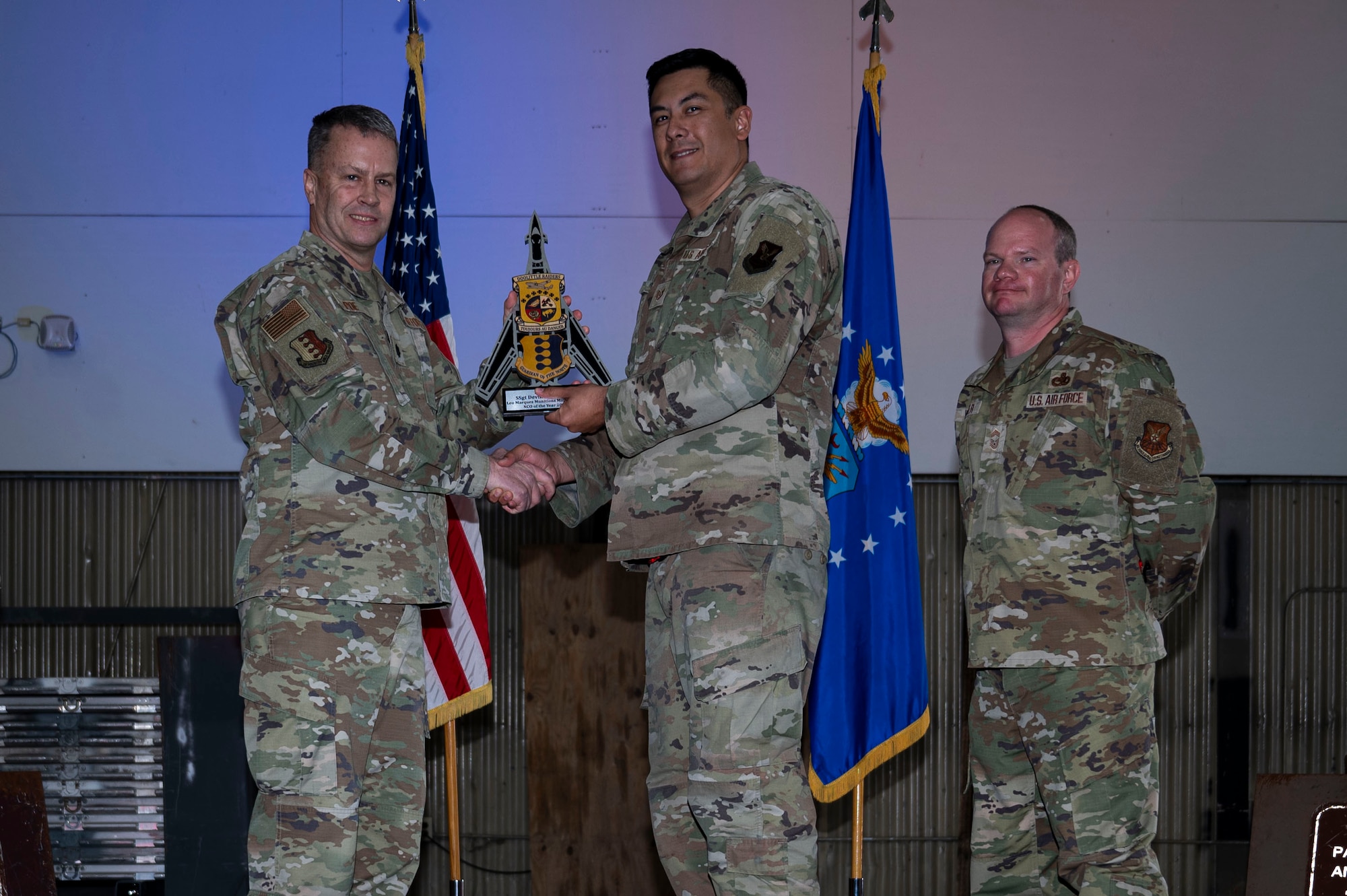 Lt. Col. Wilburn Poe, 28th Maintenance Group deputy commander and Chief Master Sgt. Daniel Werner, 37th Bomber Generation Squadron senior enlisted leader, present Staff Sgt. Devin Evangelista, 28th Munitions Squadron munitions technician, the Lt. Gen. Leo Marquez Munitions and Missiles Maintenance NCO of the Year award, at Grand Forks Air Force Base, N.D., April 25, 2025.The annual Maintenance Professional of the Year awards ceremony recognizes outstanding Airmen who went above and beyond while serving in maintenance roles. (U.S. Air Force photo by Airman 1st Class Emma Funderburk)