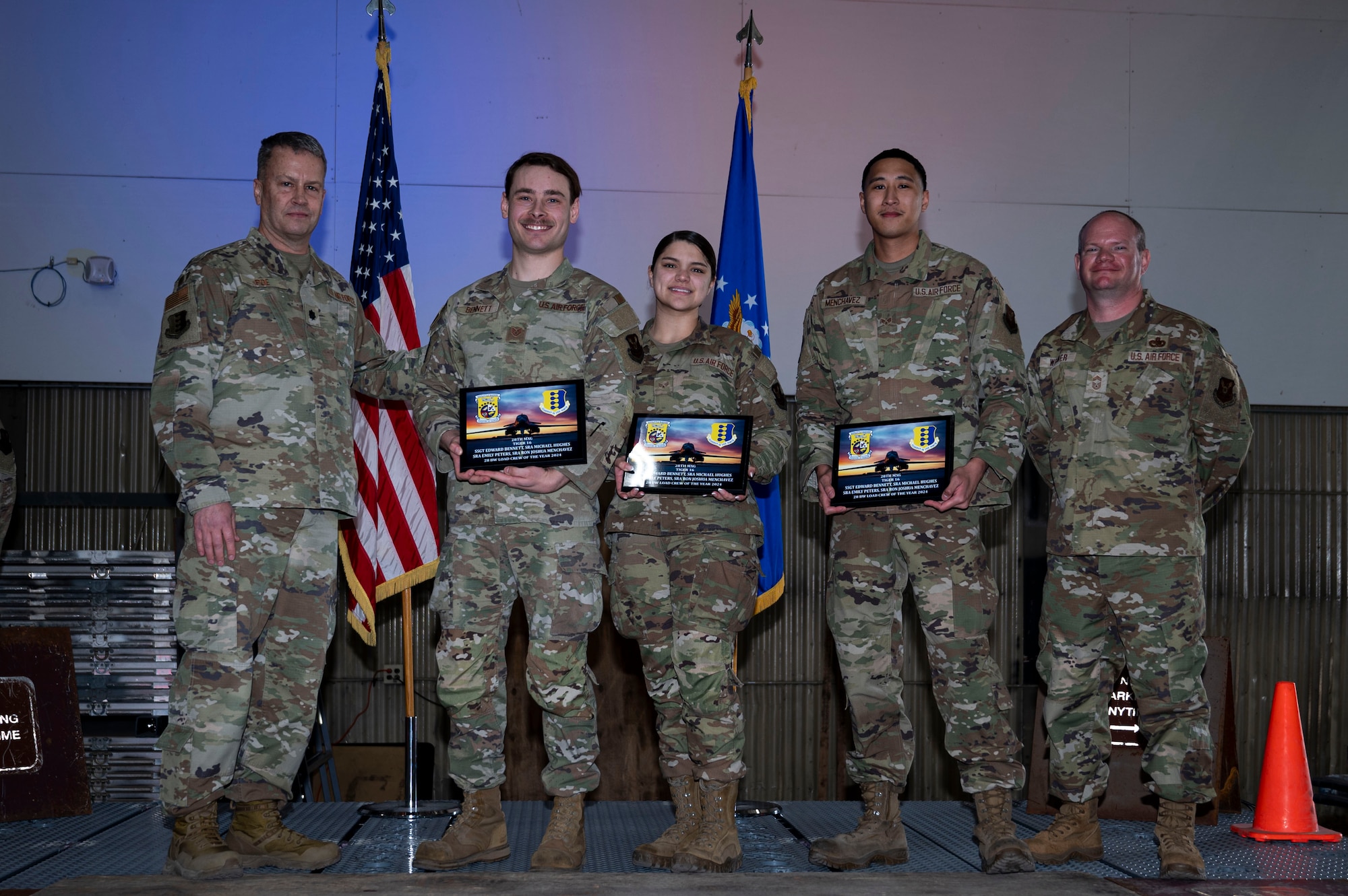 Lt. Col. Wilburn Poe, 28th Maintenance Group deputy commander and Chief Master Sgt. Daniel Werner, 37th Bomber Generation Squadron senior enlisted leader, present the 28th Bomb Wing Load Crew of the Year 2024 to Airmen assigned to the 37th Bomber Squadron, at Grand Forks Air Force Base, N.D., April 25, 2025.The annual Maintenance Professional of the Year Awards ceremony recognizes outstanding Airmen who’s work ethic and determination allows the continuation of the 28th Bomb Wings mission. (U.S. Air Force photo by Airman 1st Class Emma Funderburk)