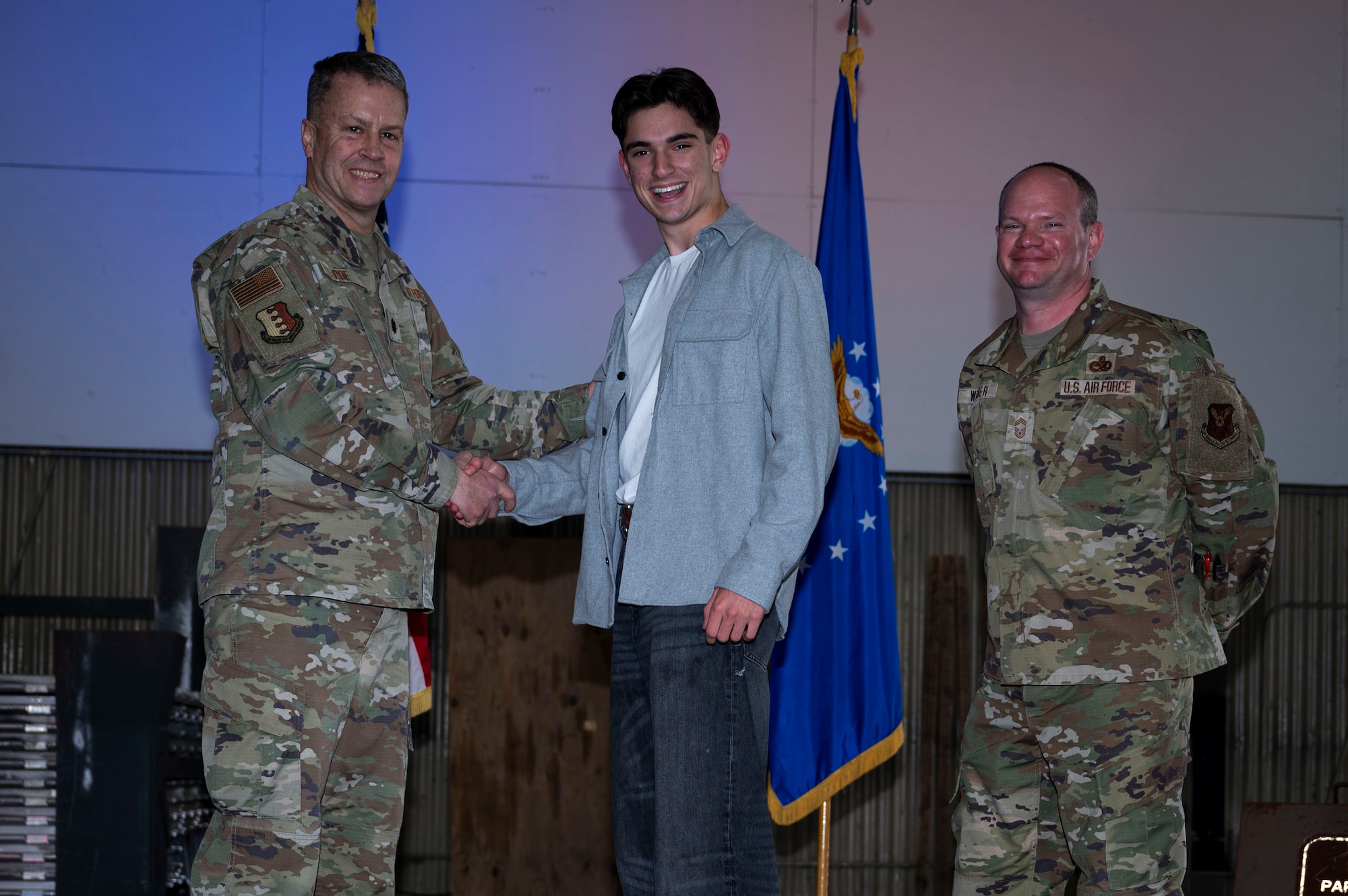 Lt. Col. Wilburn Poe, 28th Maintenance Group deputy commander, and Chief Master Sgt. Daniel Werner, 37th Bomber Generation Squadron senior enlisted leader, recognize Airman 1st Class Lucius Richner, 34th Bomber Generation Squadron maintenance scheduler, at Grand Forks Air Force Base, N.D., April 25, 2025. There were approximately 37 awards presented during the ceremony to acknowledge the commitment and hard work of the maintenance airmen of the 28th BW. (U.S. Air Force photo by Airman 1st Class Emma Funderburk)